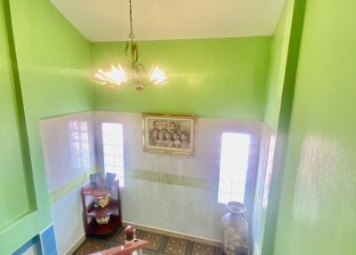 Bright staircase with green walls and chandelier