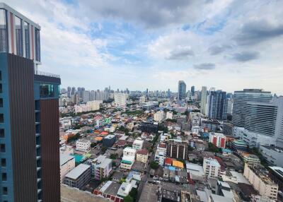 Aerial view of an urban cityscape with various buildings and a cloudy sky