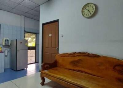 Simple kitchen area with a bench and a clock