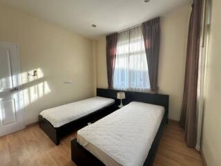 Bedroom with two single beds, sunlight coming through the window