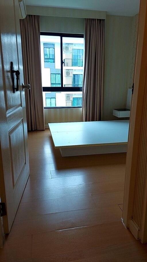 Bedroom with large window and wooden floor