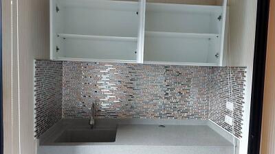 Compact modern kitchen with mosaic backsplash