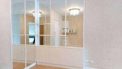 Spacious bedroom with large mirrored closet and wooden flooring