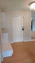 Apartment entrance with white door and wooden flooring