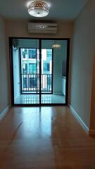 Empty living room with large sliding glass door to balcony