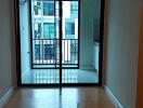 Empty living room with large sliding glass door to balcony