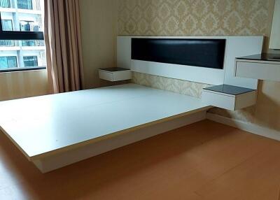 Empty bedroom with a window, wall-mounted headboard, and floating nightstands