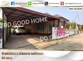 Front view of a house with a carport and real estate for sale sign