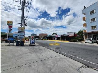 Street view with various shops and a multi-story building