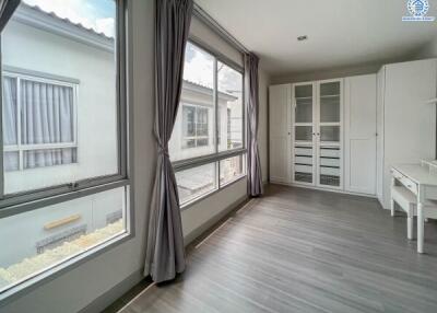 Bright bedroom with large windows and built-in wardrobe