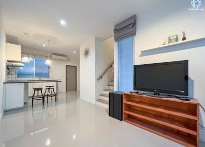 Modern living room with TV and kitchen area