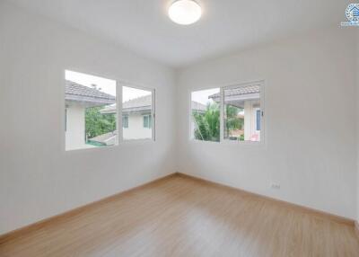 Bright bedroom with wooden floor and large windows