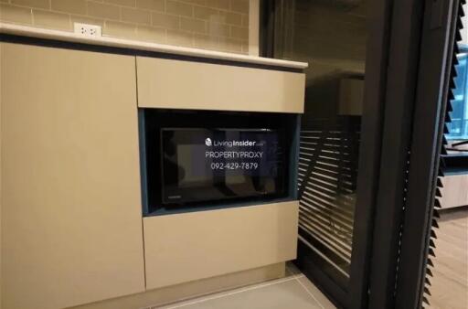 Modern kitchen with built-in microwave and high cabinets.