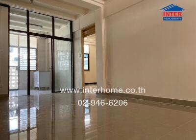 Living area with view of adjacent room through glass doors