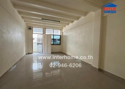 Empty unfurnished room with tiled floor, white walls, window and door at the far end