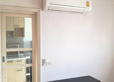 Living space with air conditioner and cabinet, view of the kitchen through glass door