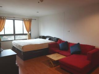 Studio apartment with bed and red sofa