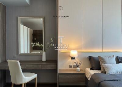 Modern bedroom with bed, nightstand, lamp, mirror, and chair