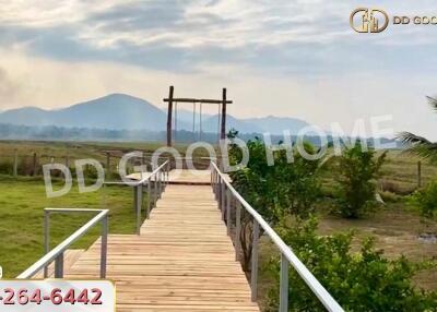 Wooden pathway leading to a swing with mountains in the background