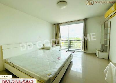 Spacious and bright bedroom with large window and balcony access.