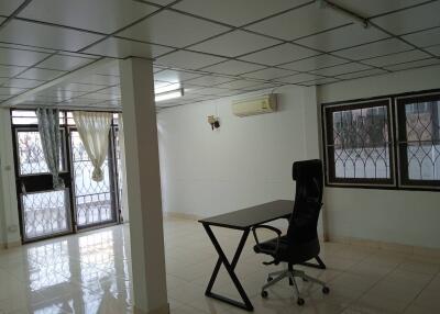 Spacious living area with large windows and office setup