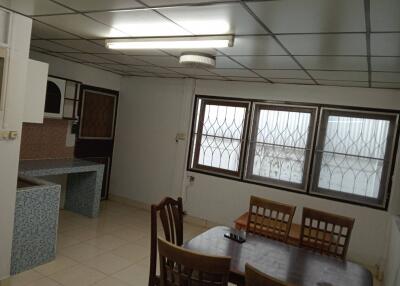 Dining area with table and chairs, adjacent to a kitchen