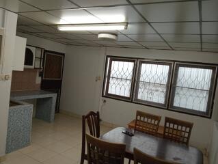 Dining area with table and chairs, adjacent to a kitchen