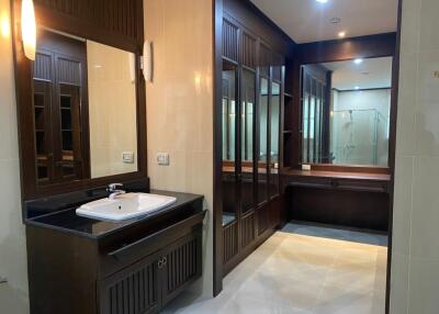 modern bathroom with large mirror and wooden cabinets
