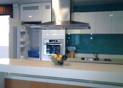 Modern kitchen with stainless steel appliances and green glass backsplash