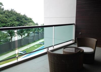 Outdoor balcony with a view of a pool and garden