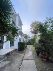 Exterior view of a residential building with a walkway and garden