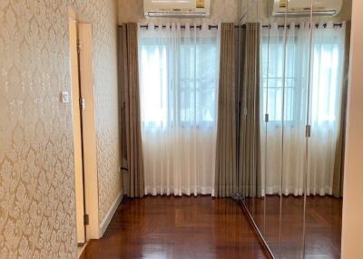 Bedroom with mirrored wardrobe and hardwood floor