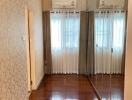 Bedroom with mirrored wardrobe and hardwood floor