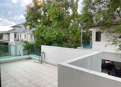 Balcony view with surrounding greenery and neighboring houses