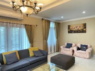 Living room with sofa, chairs, and chandelier