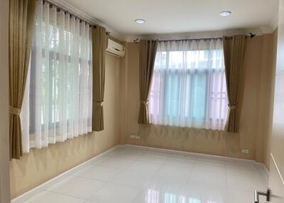 Empty bedroom with tiled floor and large windows with curtains