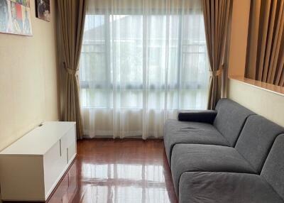 Spacious living room with a large window and a gray sofa