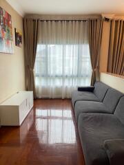 Spacious living room with a large window and a gray sofa