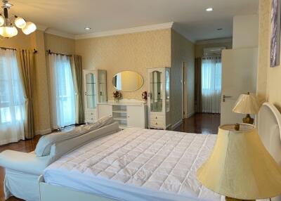 Spacious and well-lit bedroom with large bed and ample storage.