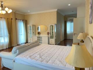 Spacious and well-lit bedroom with large bed and ample storage.