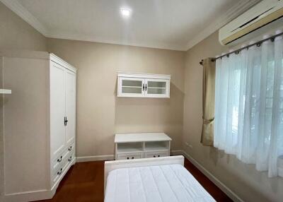 White-themed bedroom with wardrobe and air conditioning