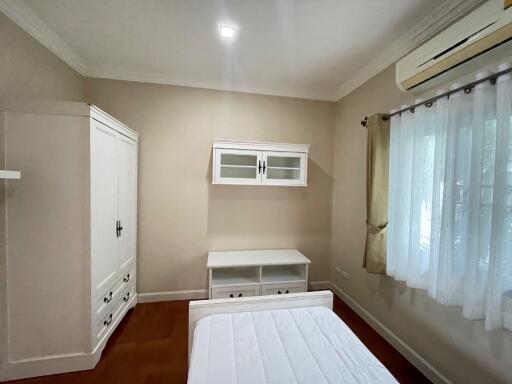 White-themed bedroom with wardrobe and air conditioning