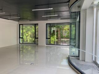 Spacious open area in a modern building with large glass windows and a shiny tile floor