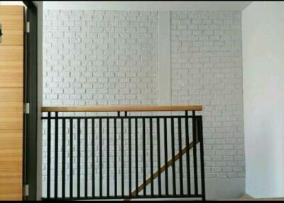 Modern interior staircase with black railings and white brick walls