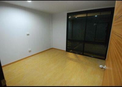 Empty bedroom with wooden flooring and a large window