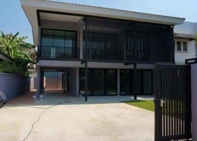 Modern two-story house with large windows and gated driveway