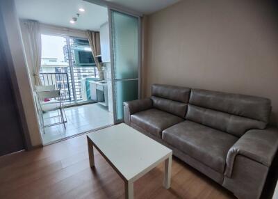 Modern living room with balcony access and kitchen area