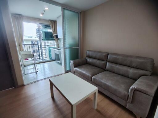 Modern living room with balcony access and kitchen area