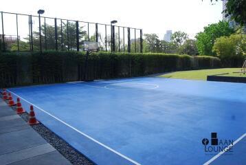 Outdoor basketball court with greenery