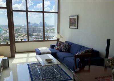 Spacious living room with large windows and city view